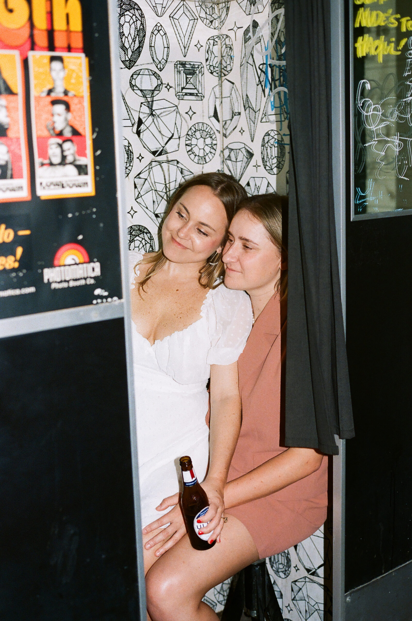 Couple in a photobooth during a dive bar engagement photo session