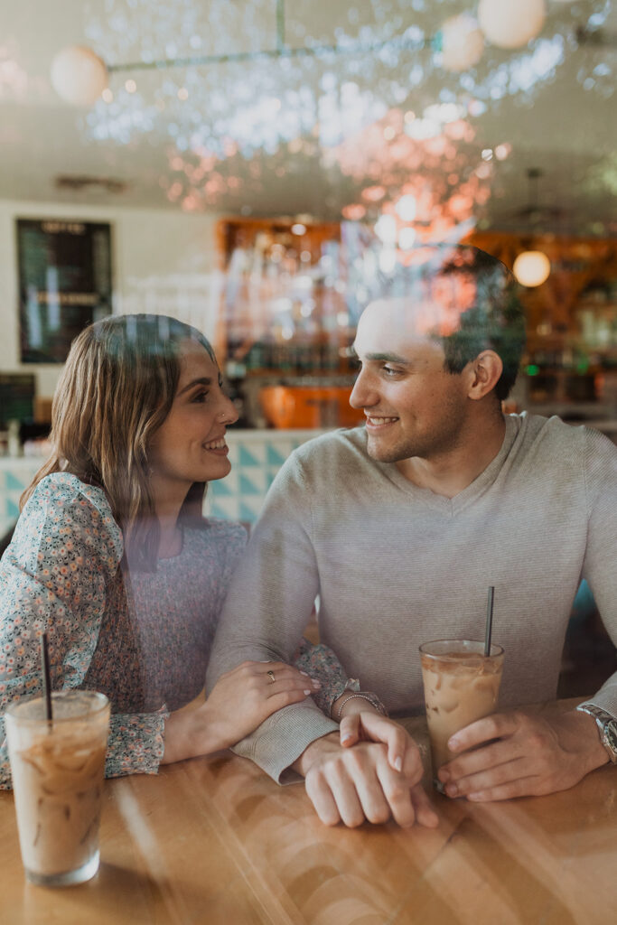couple poses for engagement photo at Halcyon Coffee Shop in Austin, Texas
