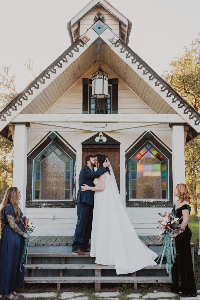 Couple sharing their first kiss during their wedding ceremony at the Tiny T Ranch chapel
