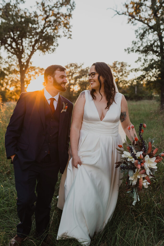 couple walking through a field at Tiny T Ranch after getting married