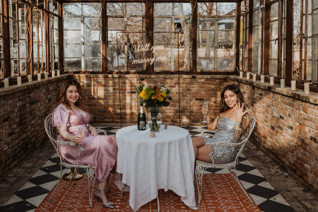 Two women celebrate their engagement at Sekrit Theater in Austin, Texas. Amore Austin helped them know how to propose in an unforgettable way.