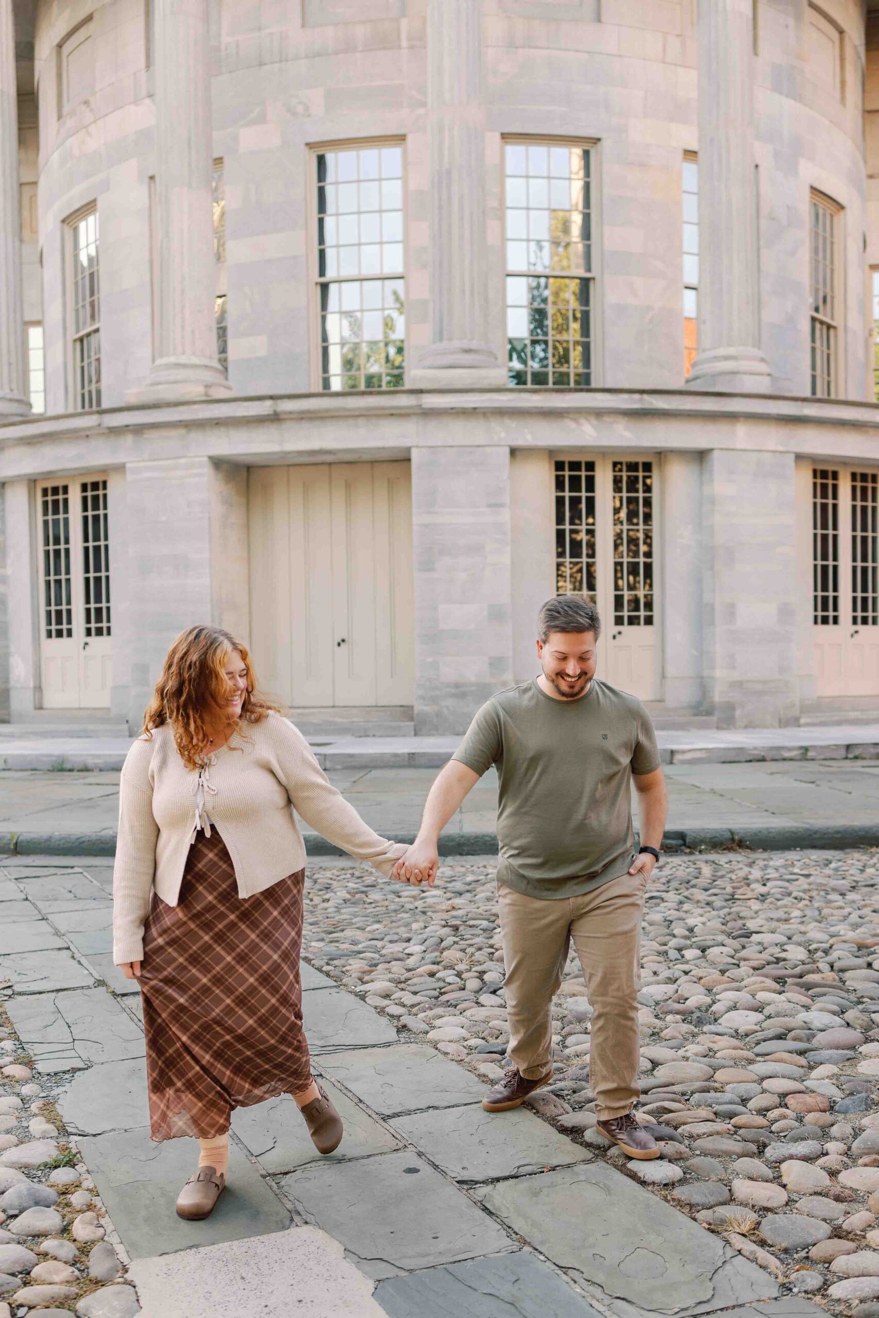 Couple poses for photos in front of the Merchant Exchange Building in Old City Philadelphia