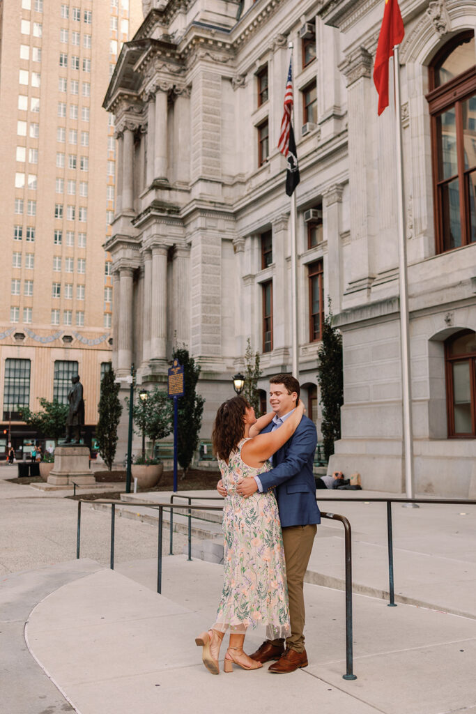 Couple poses for engagement photos outside City Call in Philadelphia