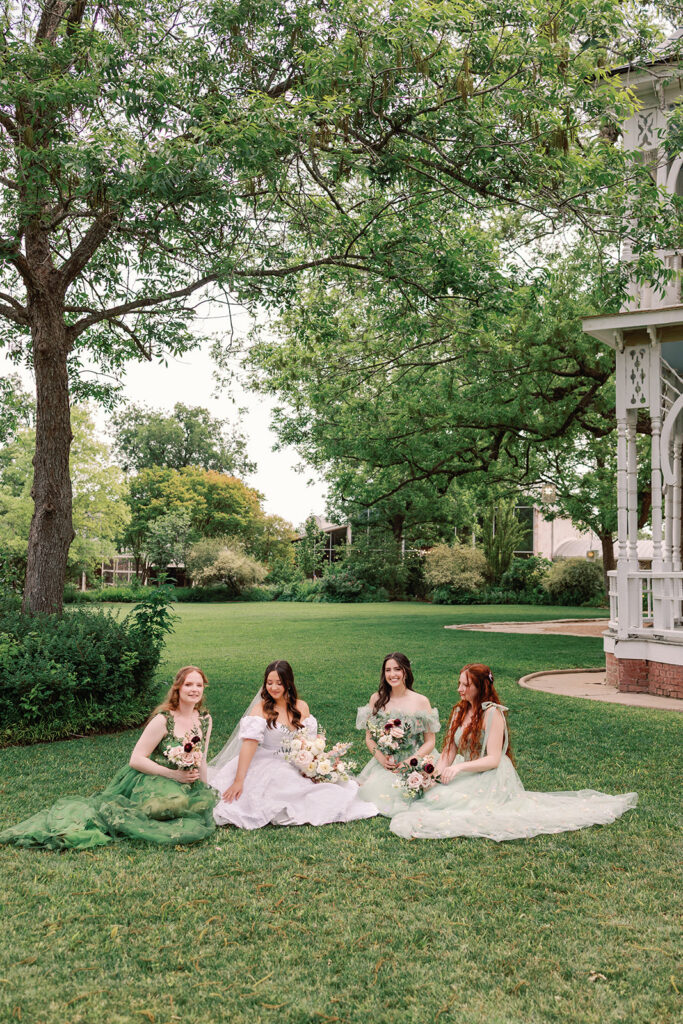 Bridesmaids sitting on the Barr Mansion lawn 